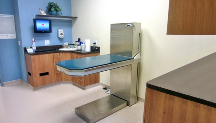 An exam and treatment room with a hydraulic lift table