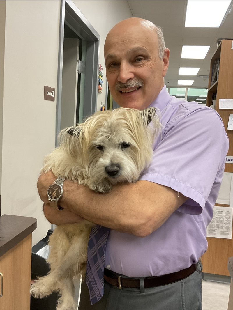 Dr. Ronald J. Busack holding a terrier in the hospital